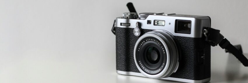 black and gray film camera near printed photos